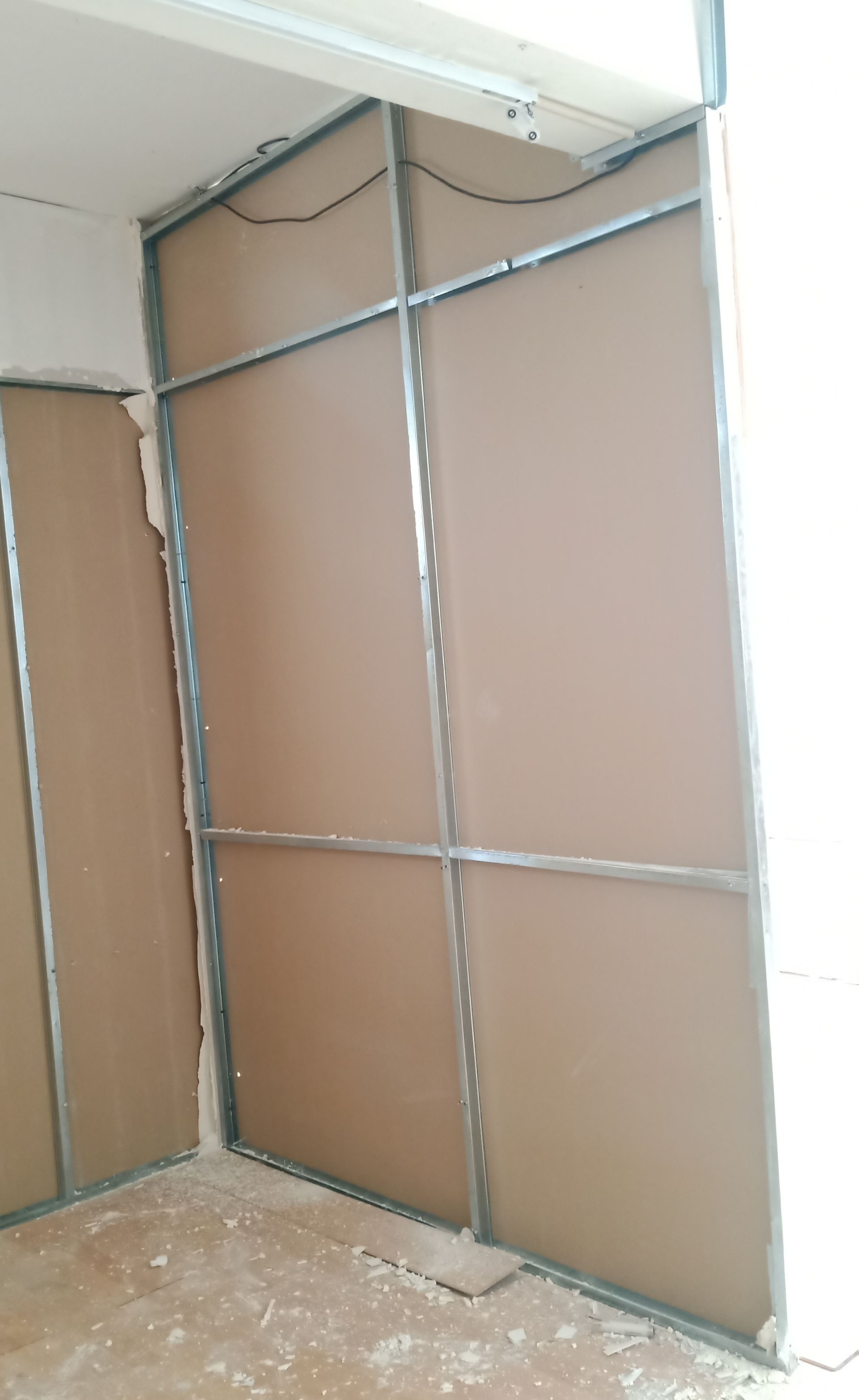 Estrutura metálica e painéis marrons instalados no interior de um cômodo, provavelmente durante uma construção ou reforma.