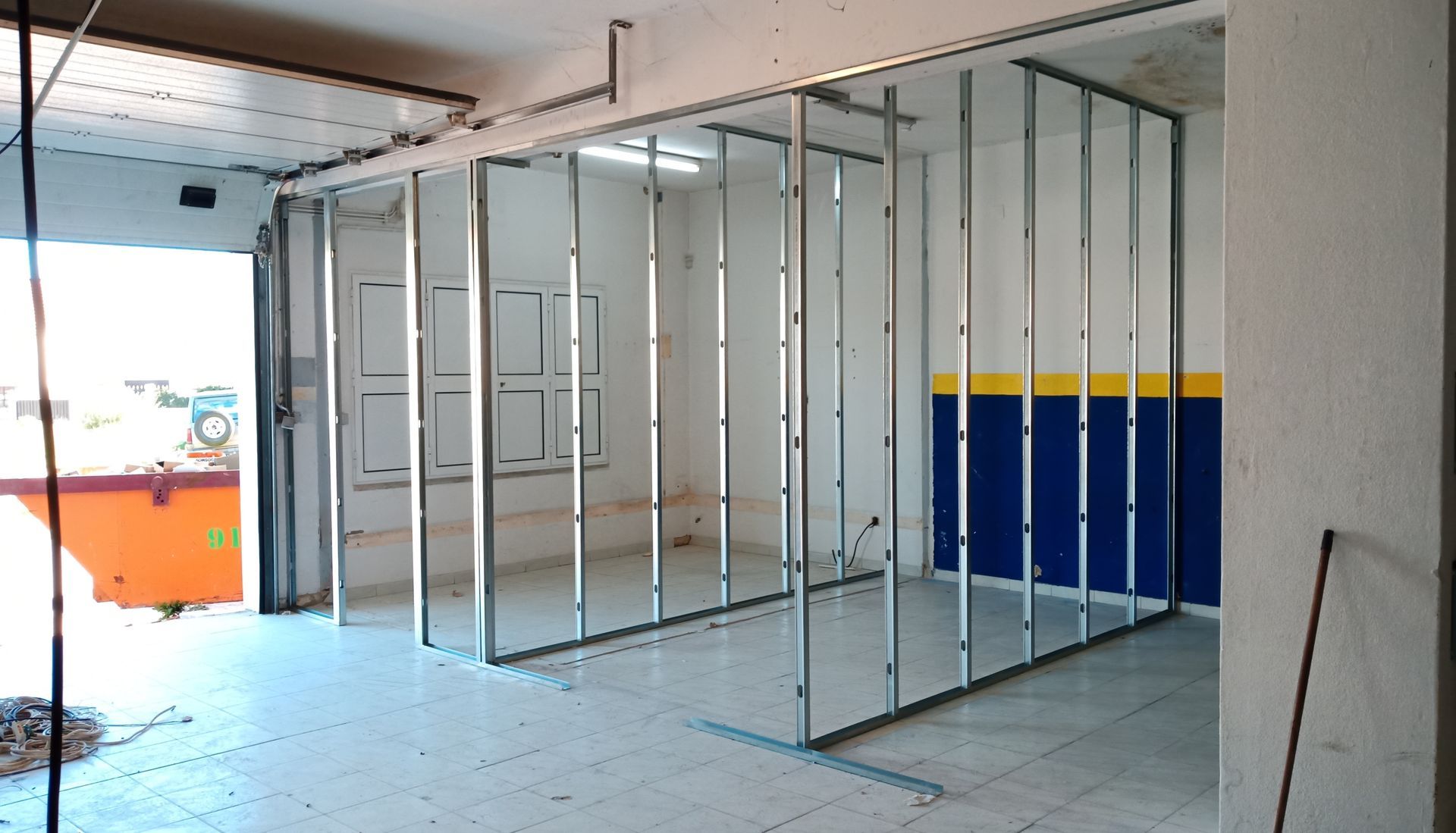 Estrutura metálica para paredes internas de um cômodo, com a parede pintada existente à mostra.