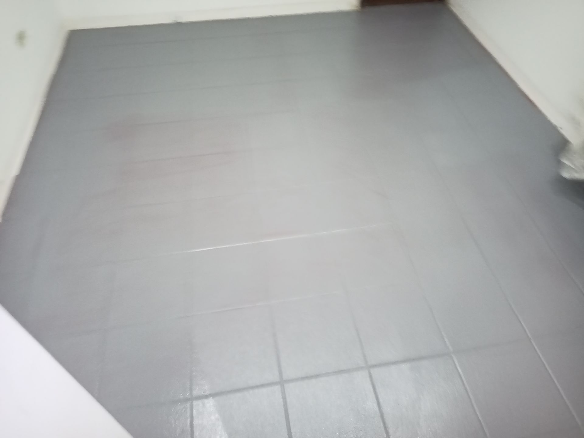 Piso de azulejo pintado de cinza em um cômodo.