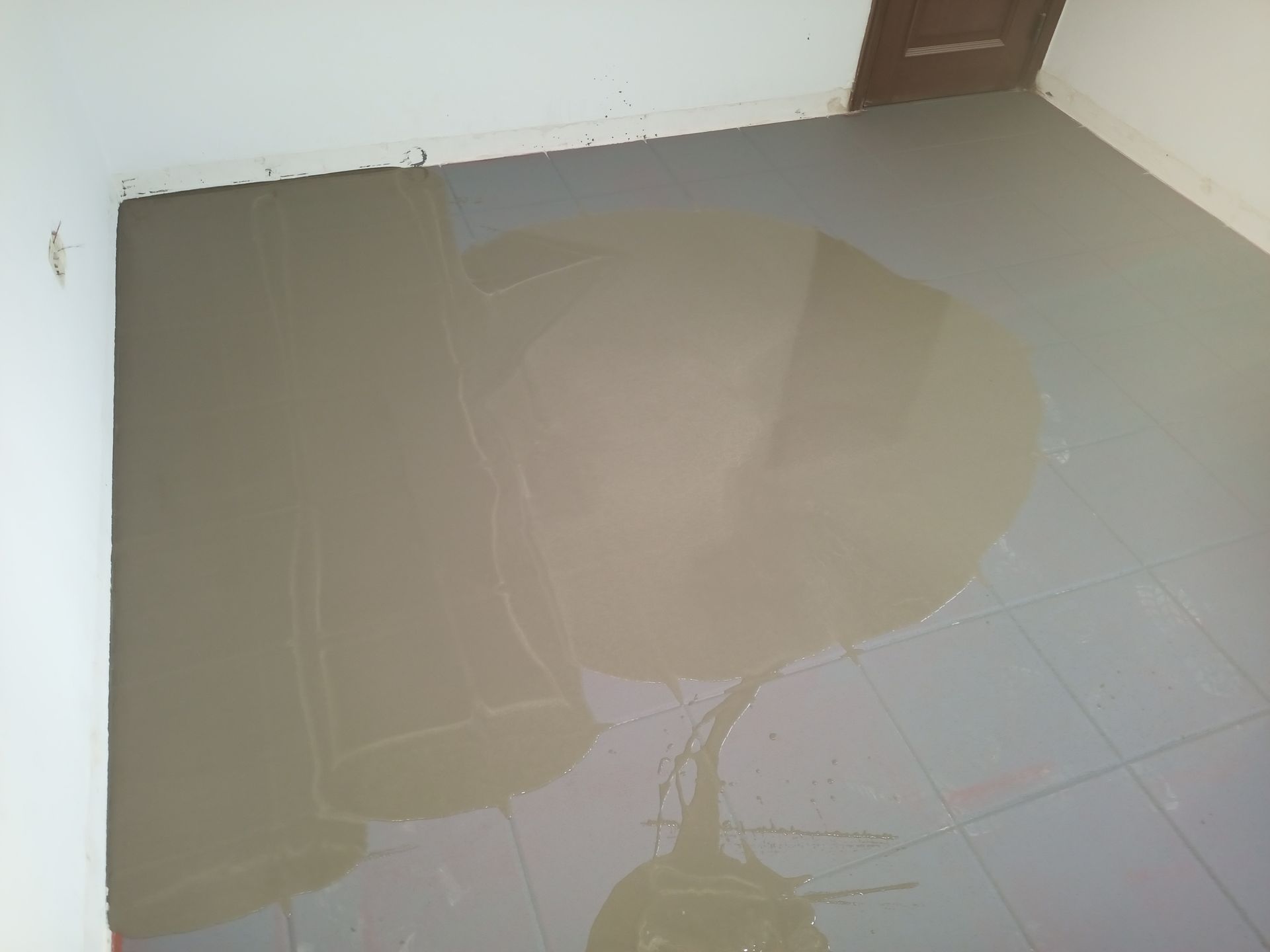 Quarto com piso parcialmente revestido com azulejos em tons de cinza.