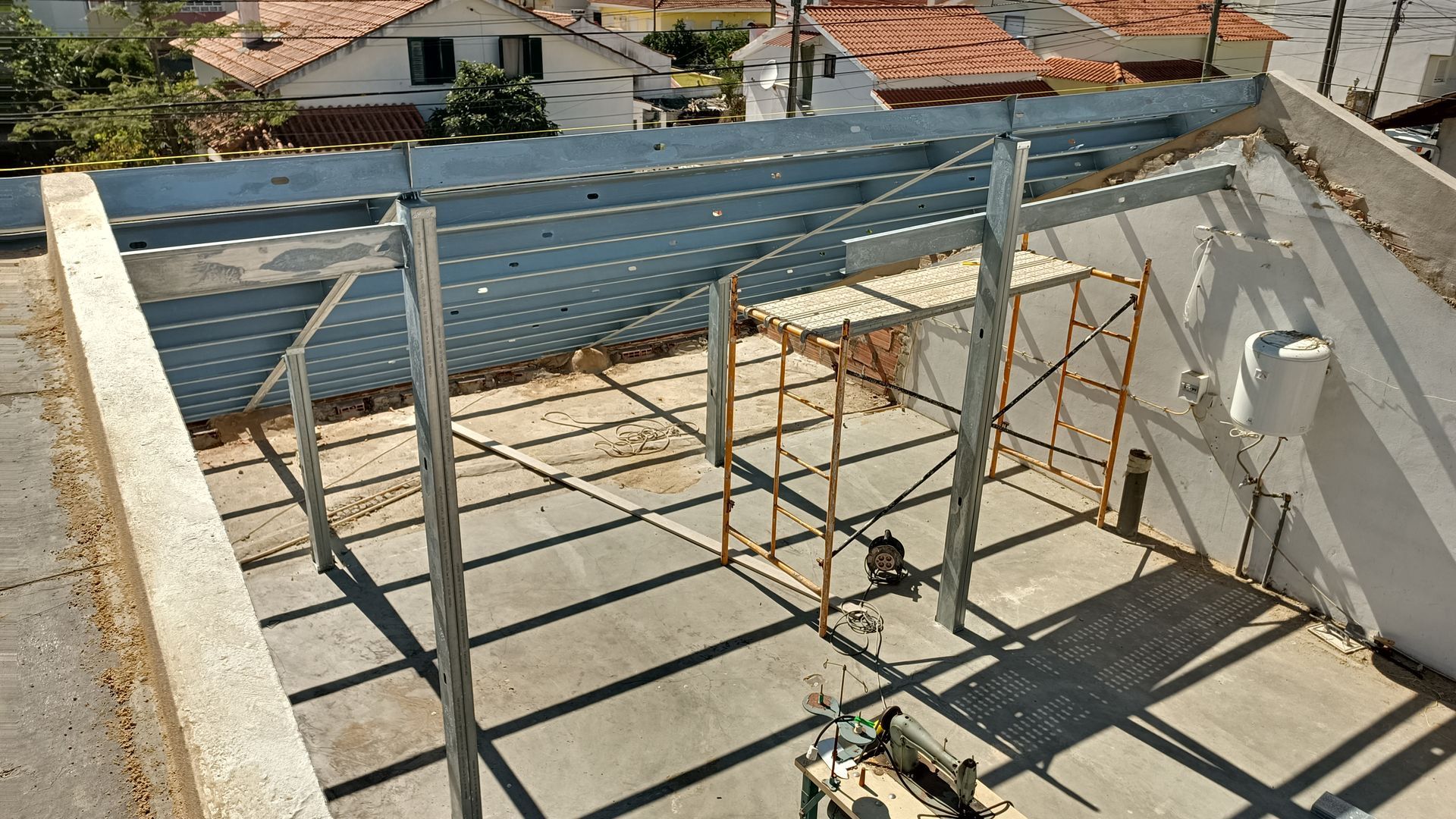 Estrutura de aço sobre plataforma de concreto. Andaimes visíveis.