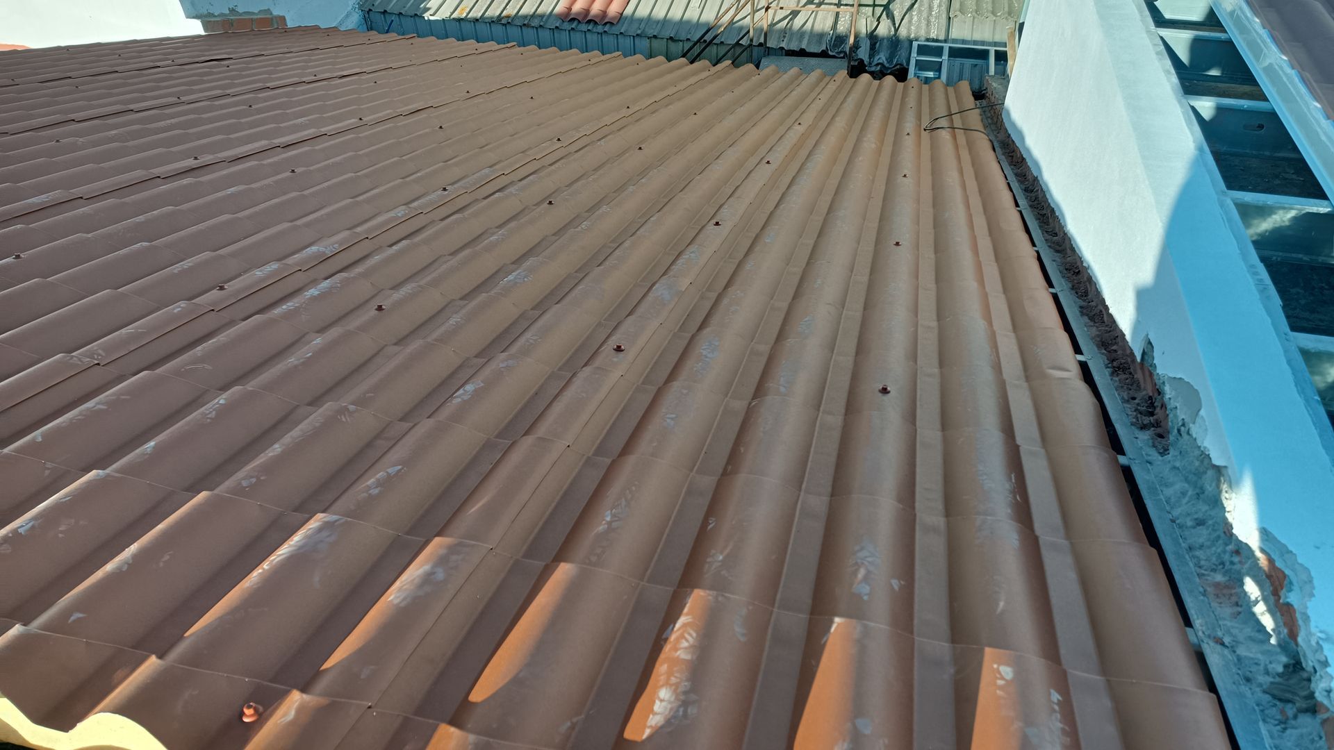 Vista aproximada do telhado ondulado marrom de um edifício.