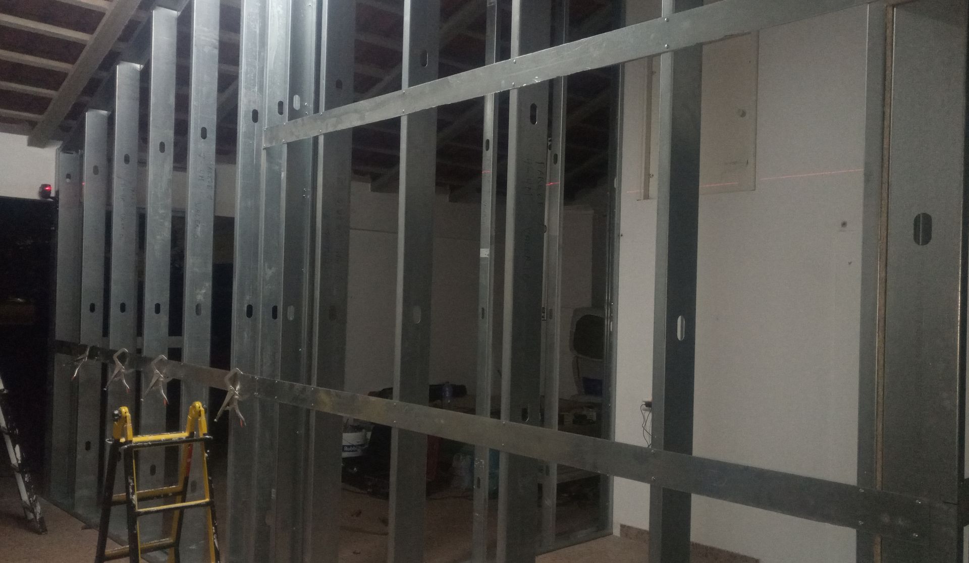 Estrutura metálica emoldurando uma parede interna, provavelmente em construção.