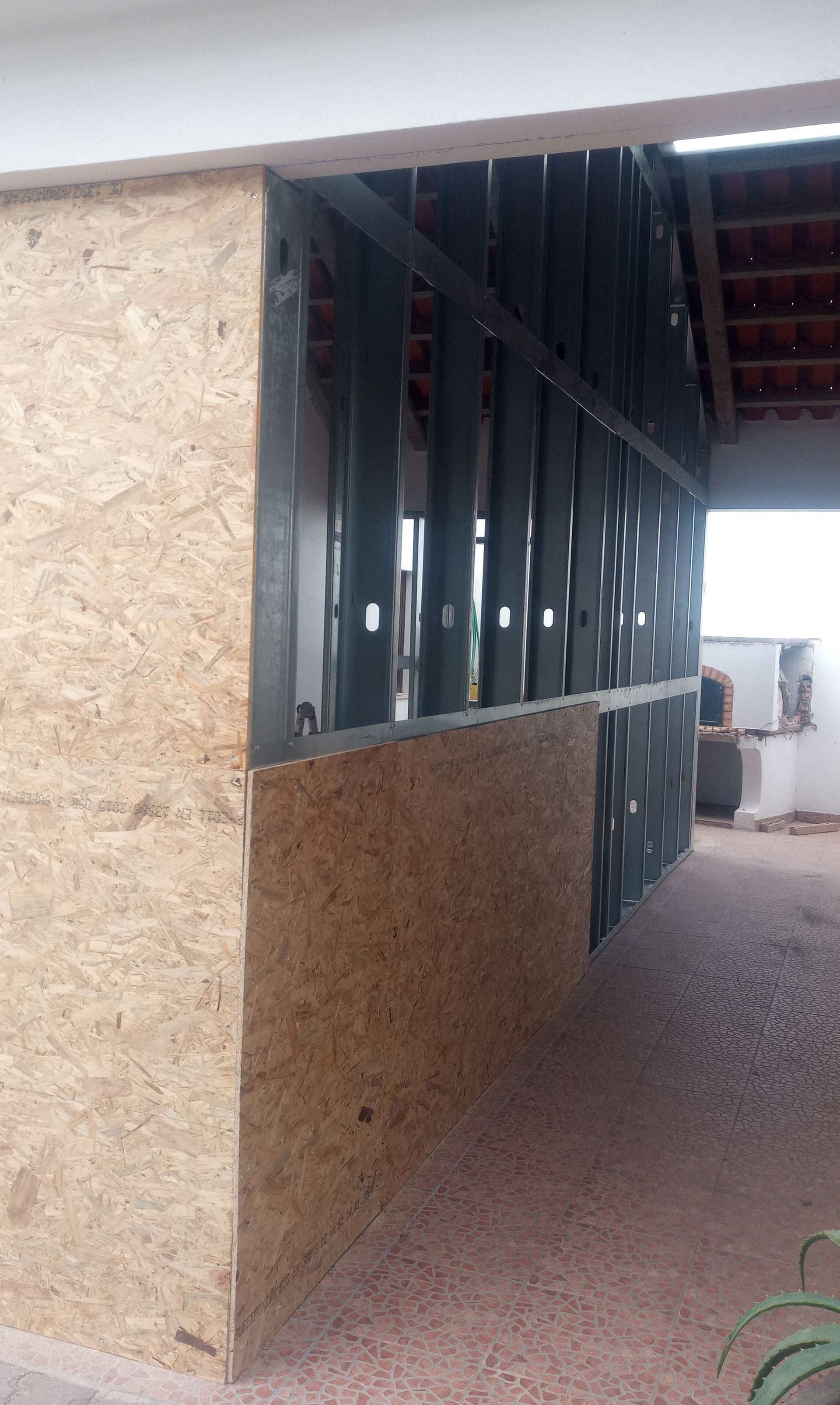 Construção de uma seção de parede com painéis de madeira OSB e estrutura de aço.