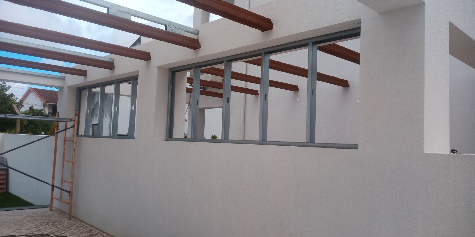 Exterior de um edifício com várias janelas e uma área de pátio coberta.