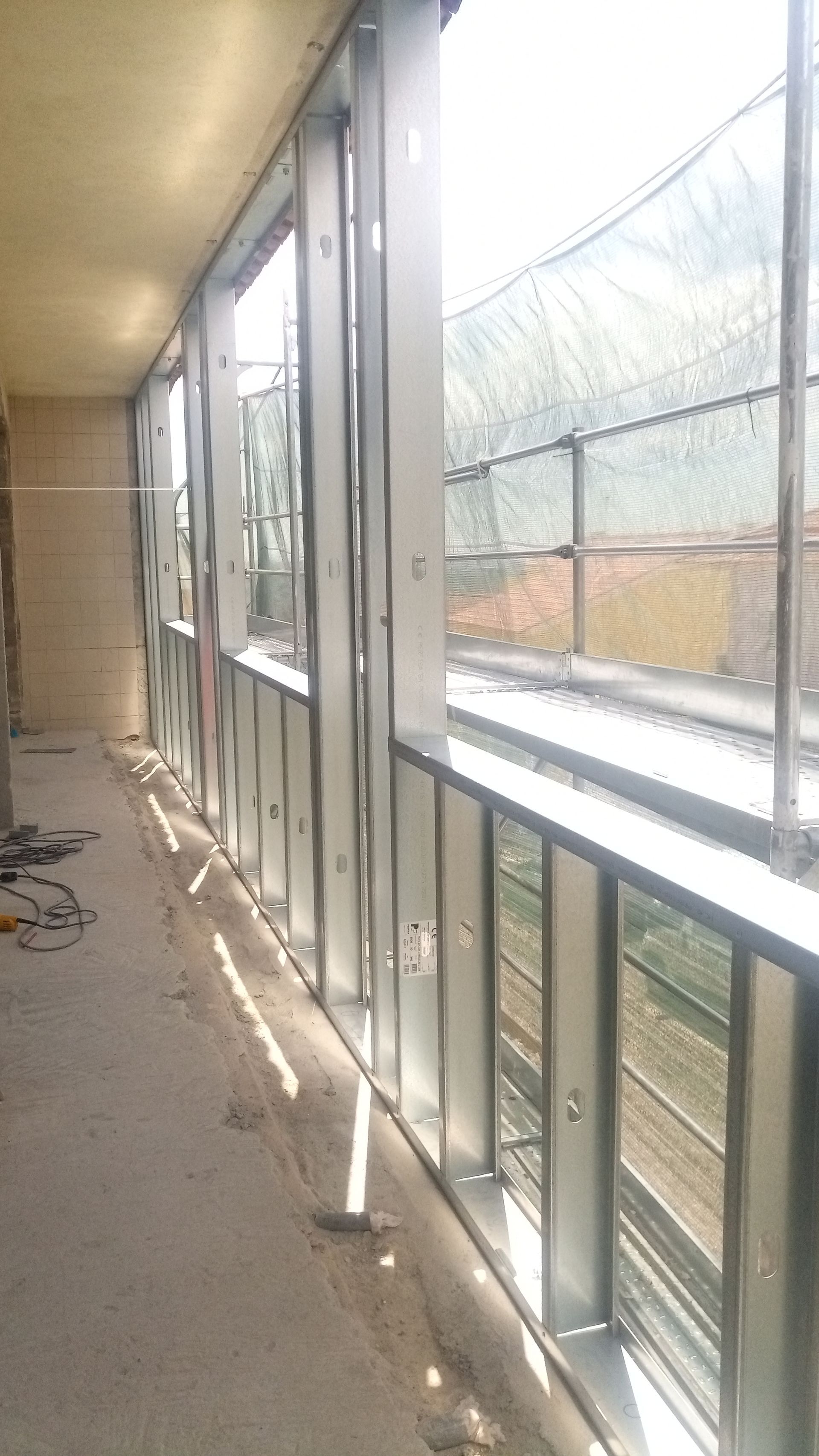 Estrutura metálica para janela e parede em construção. Vista interna com vista para o exterior.