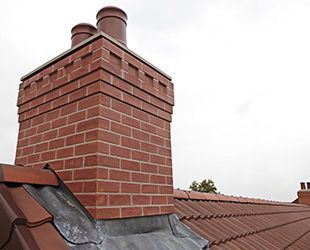 a brick chimney is sitting on top of a roof .
