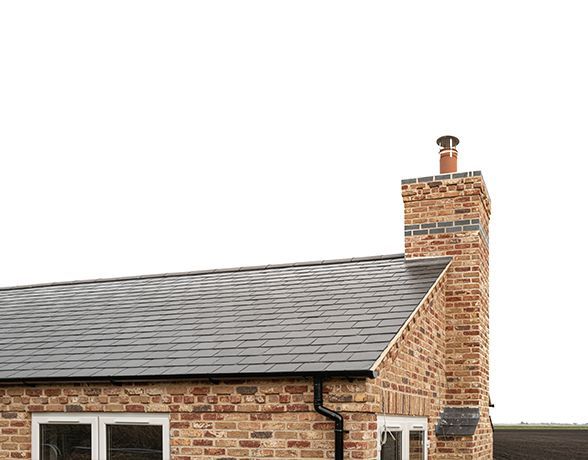 a brick house with a chimney on top of it .