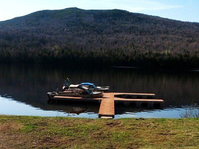 A boat is docked at a dock on a lake