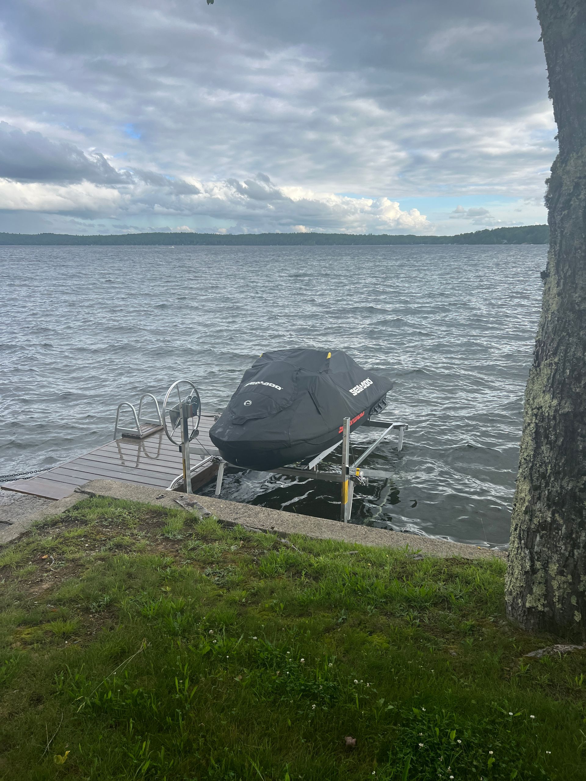 A boat is docked on a dock next to a lake.