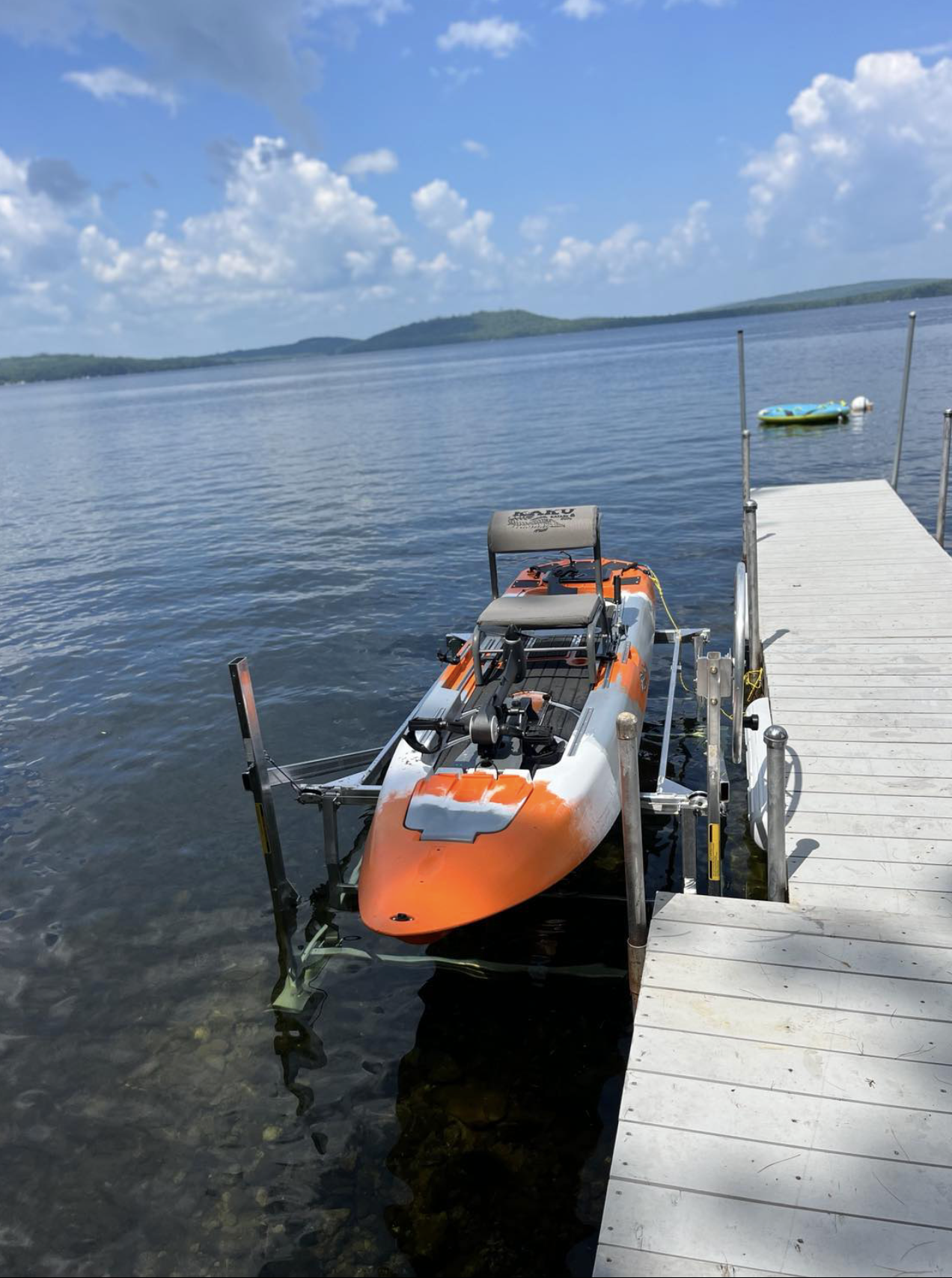 an orange and white kayak is docked at a dock