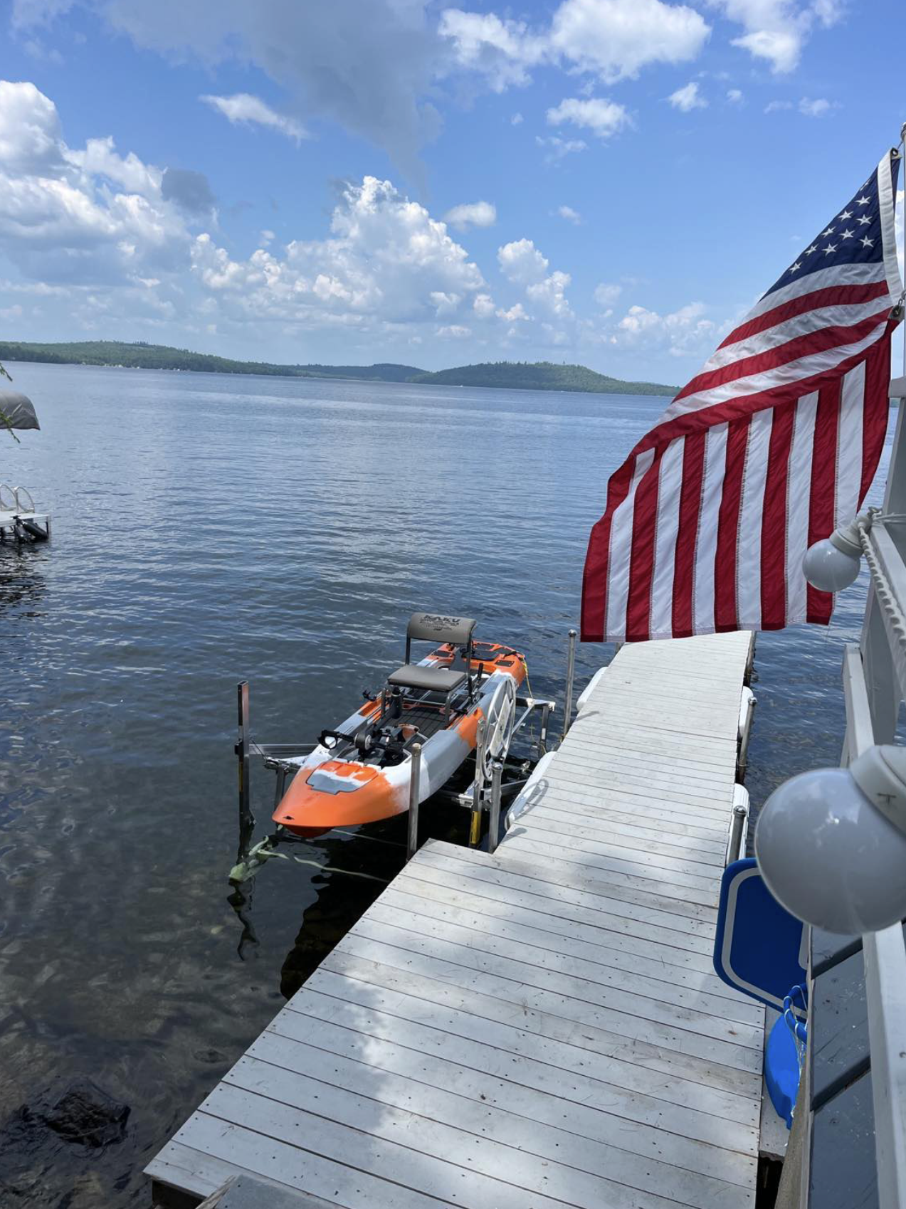 A boat is docked at a dock with an american flag flying in the background.