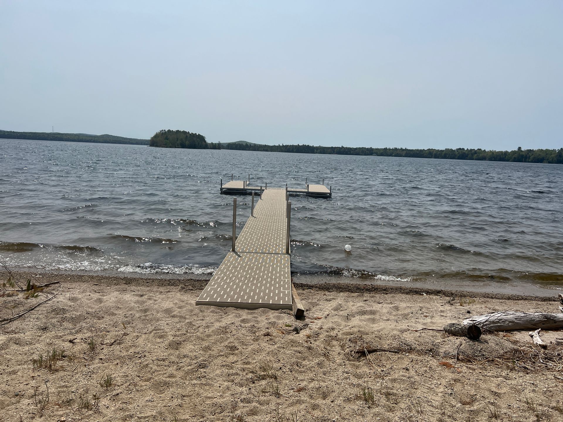 A dock is sitting on the shore of a lake.