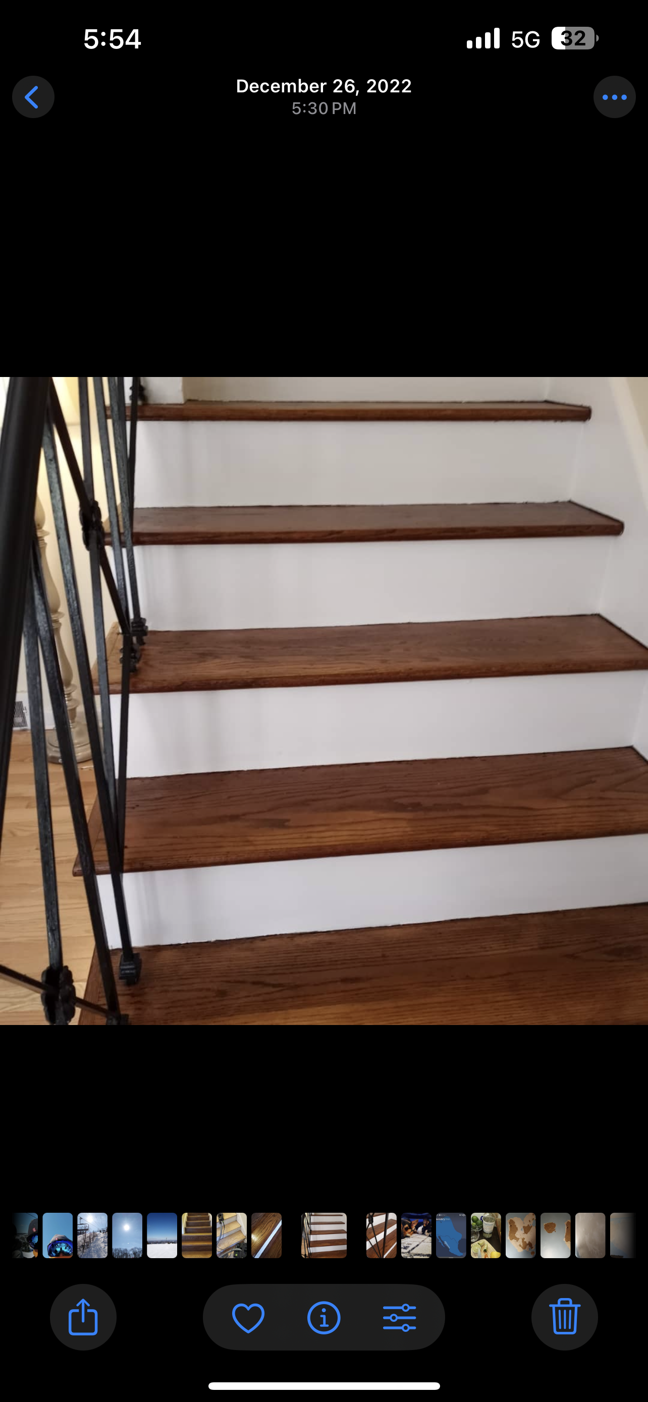 A close-up of a modern grey stone countertop with a textured edge, set above dark matte cabinets in a kitchen.