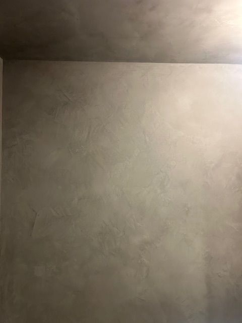 A wall with a smooth, mottled gray finish showing subtle variations in texture and shading.