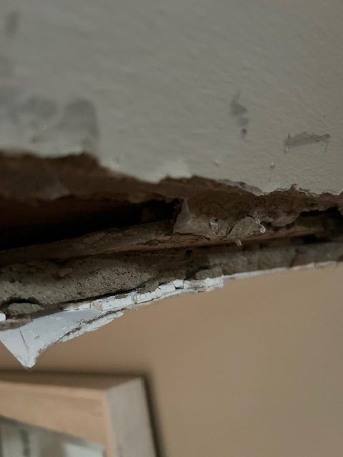 A white epoxy countertop with dark, marble-like veins, shown in a workshop setting with protective drop cloths on the floor.
