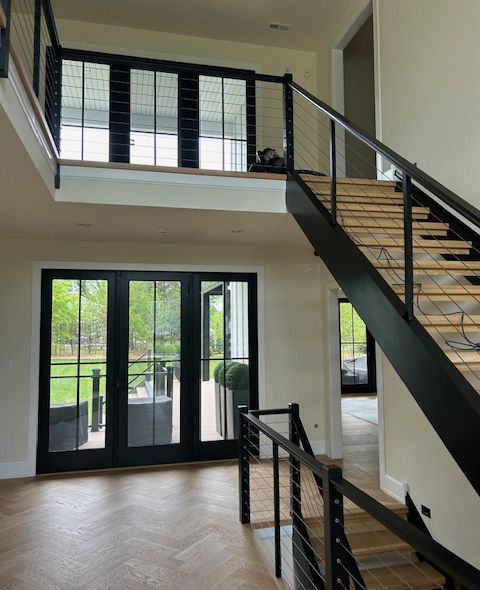 Modern white kitchen island with marble-look countertop, gold faucet, and built-in stovetop in a bright, white kitchen.