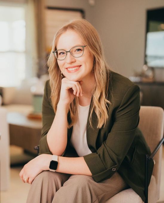 A woman is sitting in a chair in a living room.