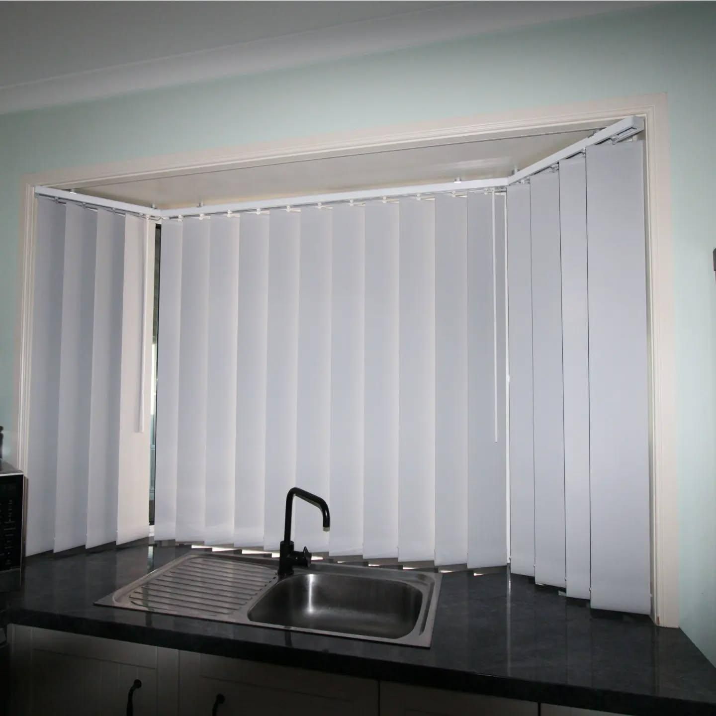A Kitchen with A Sink and Vertical Blinds on The Window — Barry's Affordable Blinds in Taylors Beach, NSW