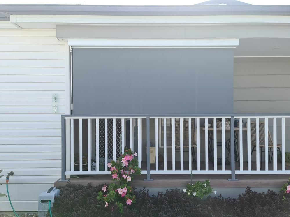 A White House with A Porch with A White Railing and Awning in Front of It — Barry's Affordable Blinds in Taylors Beach, NSW