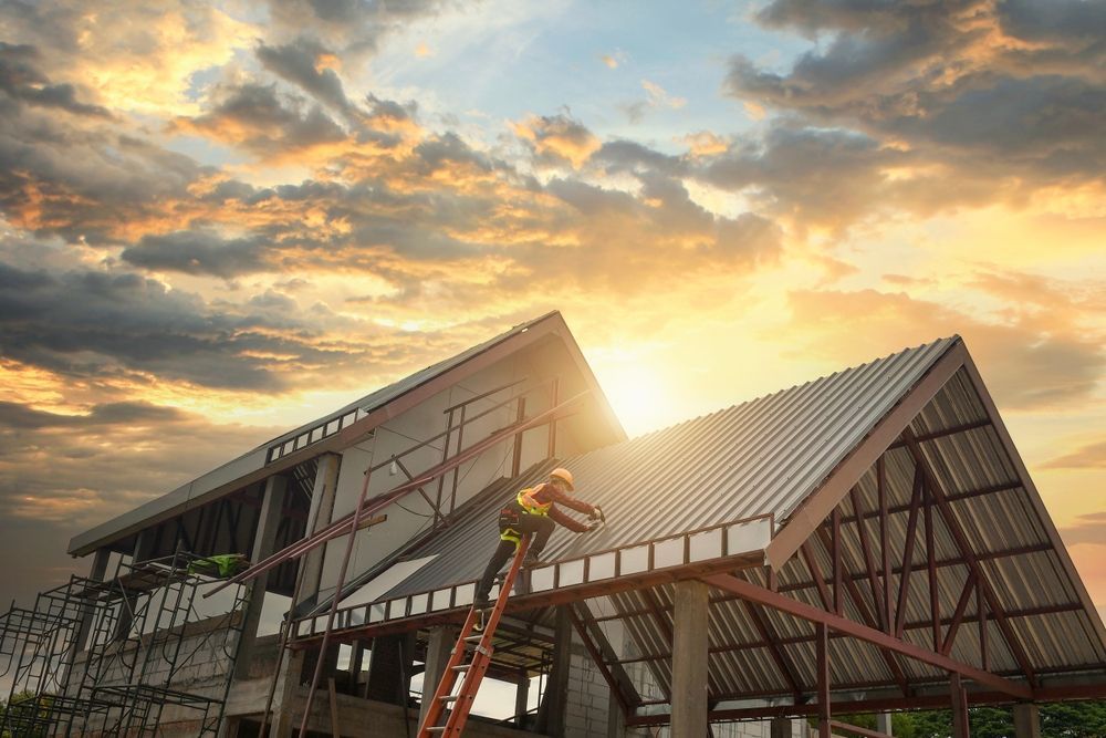 A man is standing on a ladder on top of a building under construction.