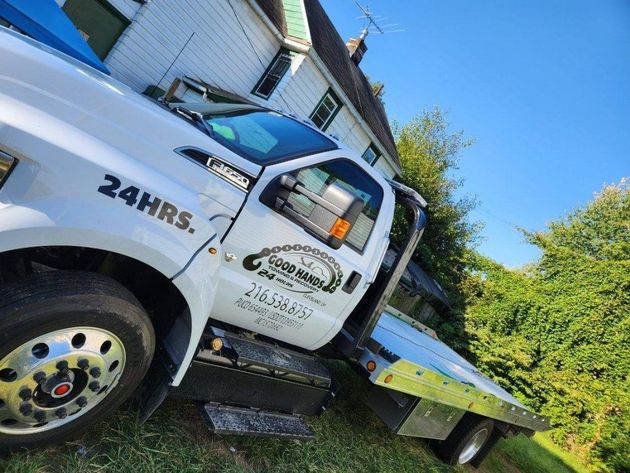 A white tow truck is parked in front of a house.