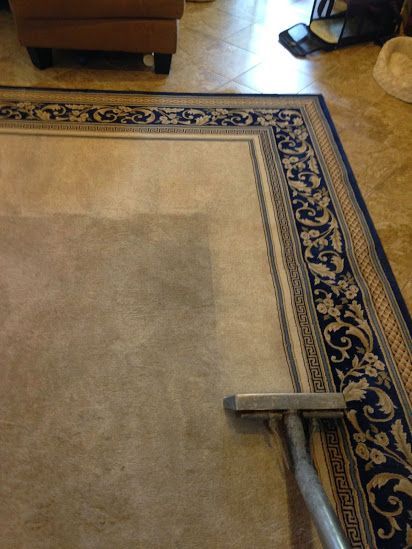 A vacuum cleaner is cleaning a rug in a living room.