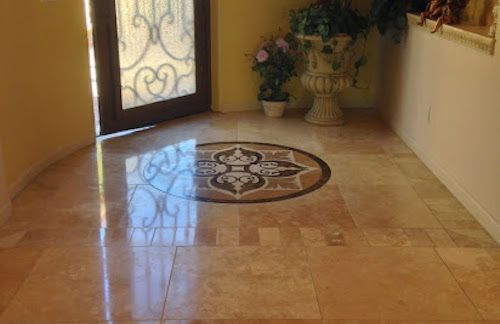 A hallway with a tiled floor and a mosaic in the middle.