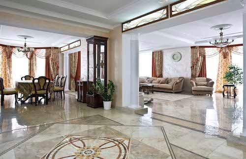 A large living room filled with furniture and a marble floor.