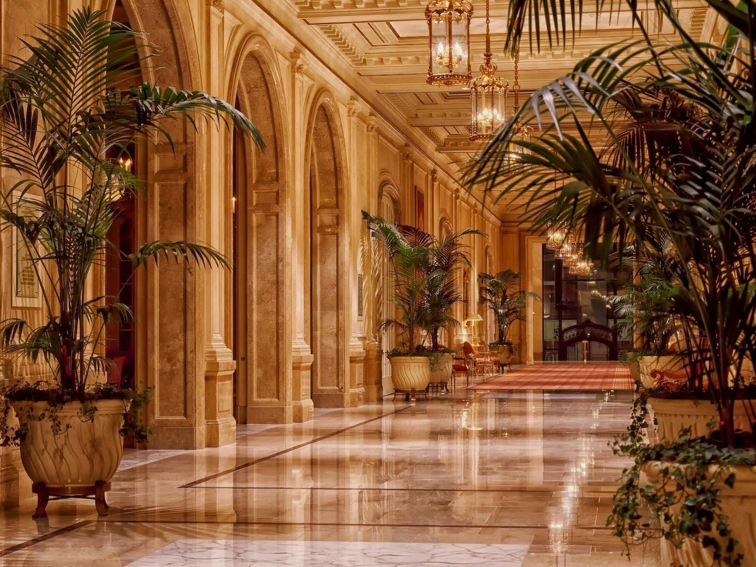 There is a table with flowers on it in the middle of the lobby.