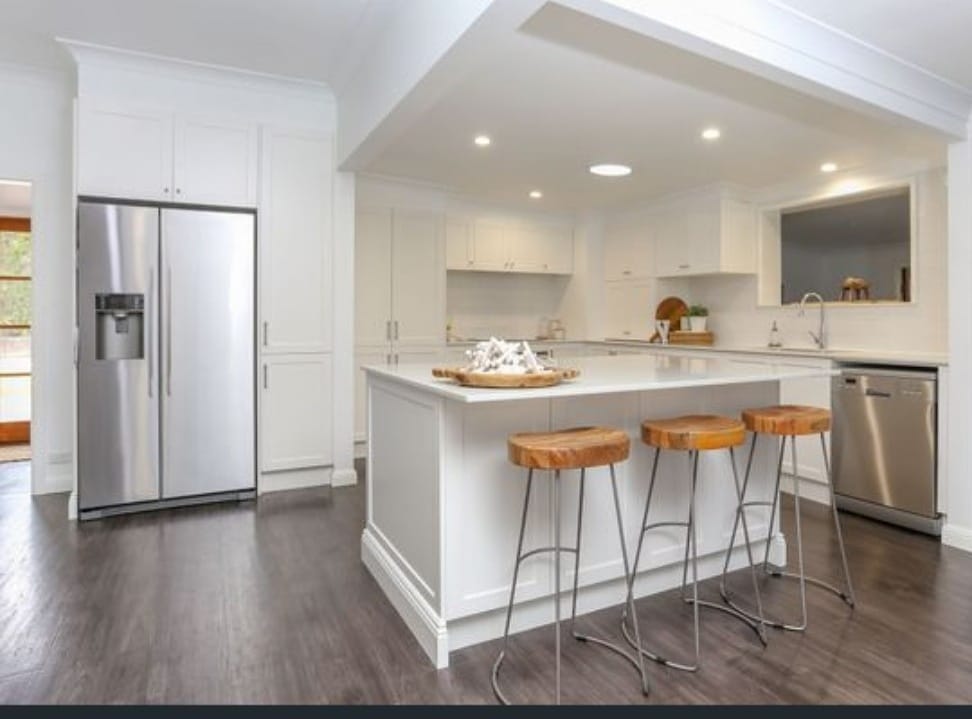 White Kitchen With Orange Chairs — DMB Kitchens in Port Macquarie, NSW