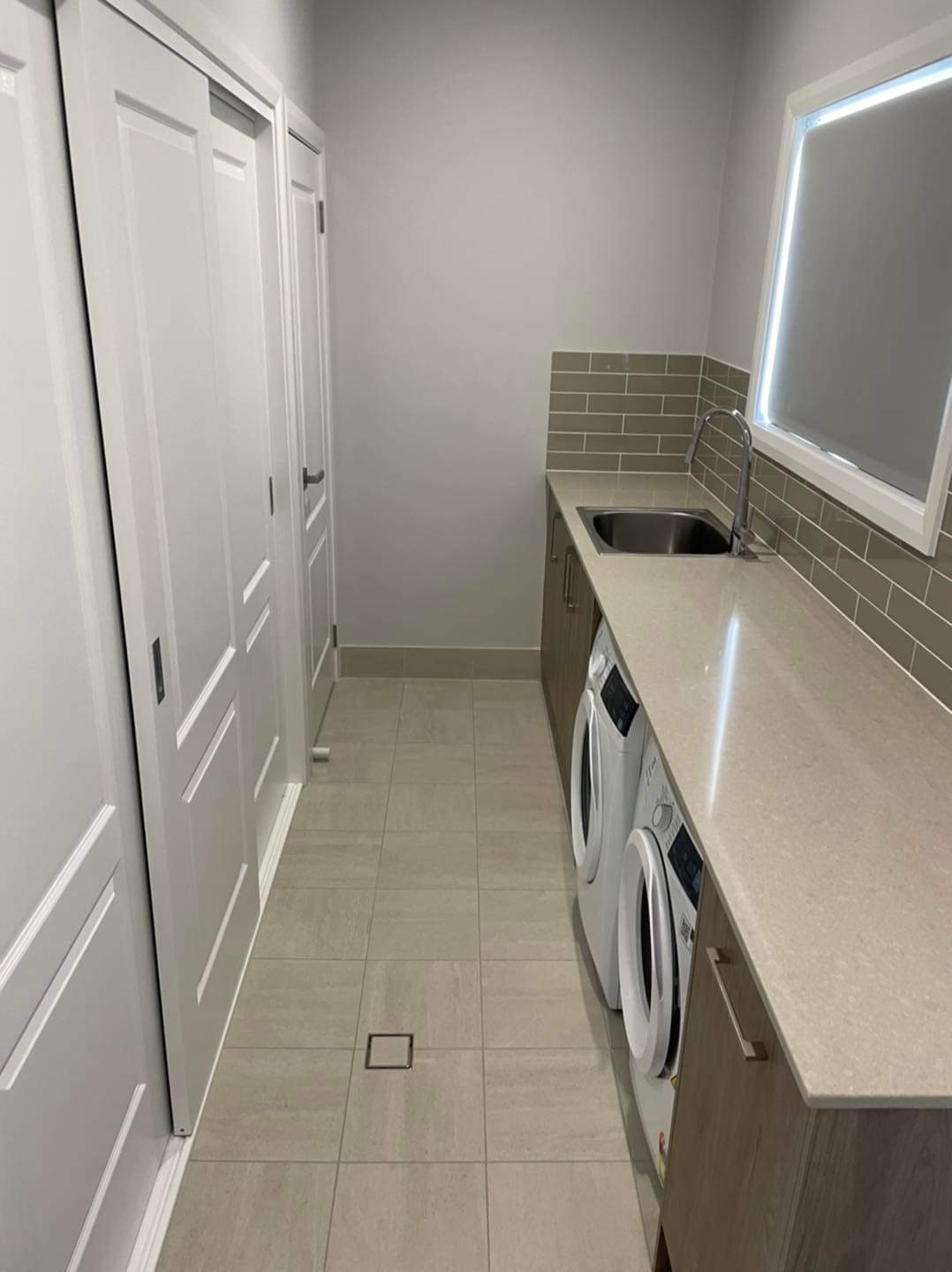 White and Brown Laundry With Sliding Storage and Marble Bench  — DMB Kitchens in Port Macquarie, NSW