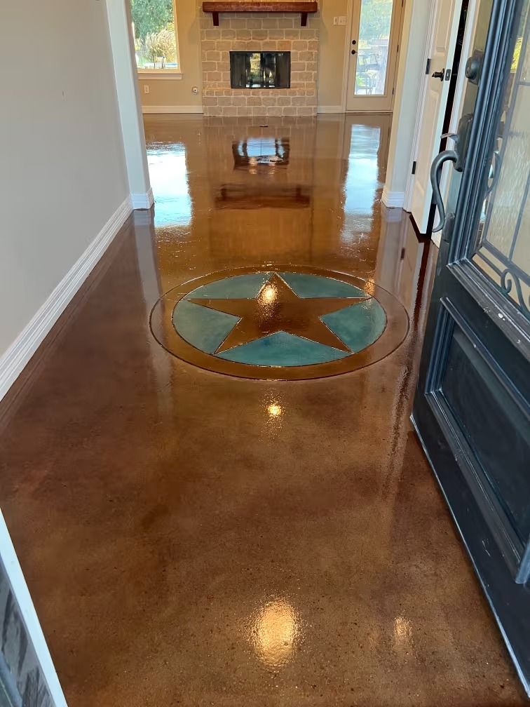 Polished brown concrete floor with a teal and brown star inlay; entryway.