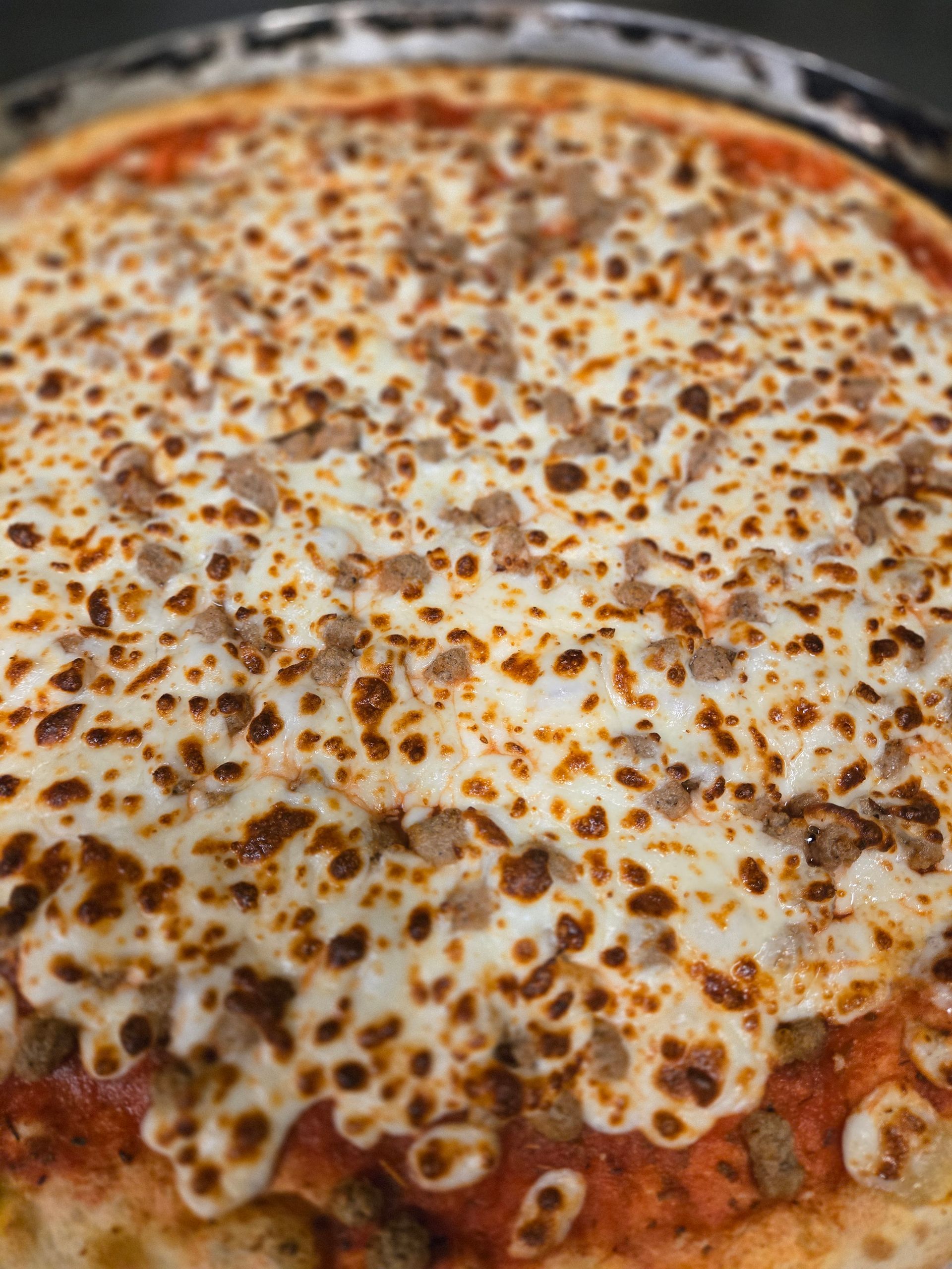 A close up of a pizza with a lot of cheese on it.