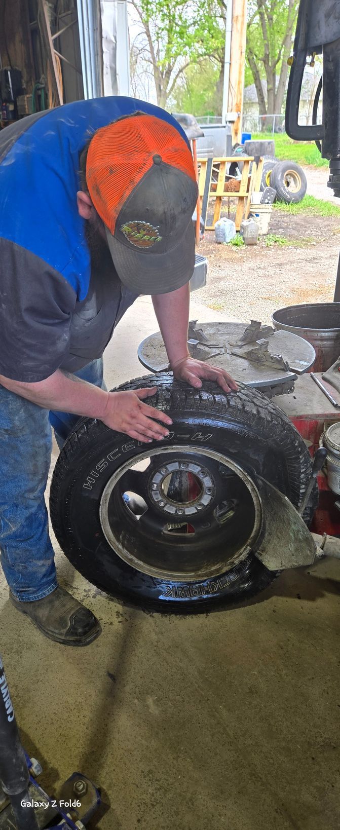A man is working on a tire in a garage.