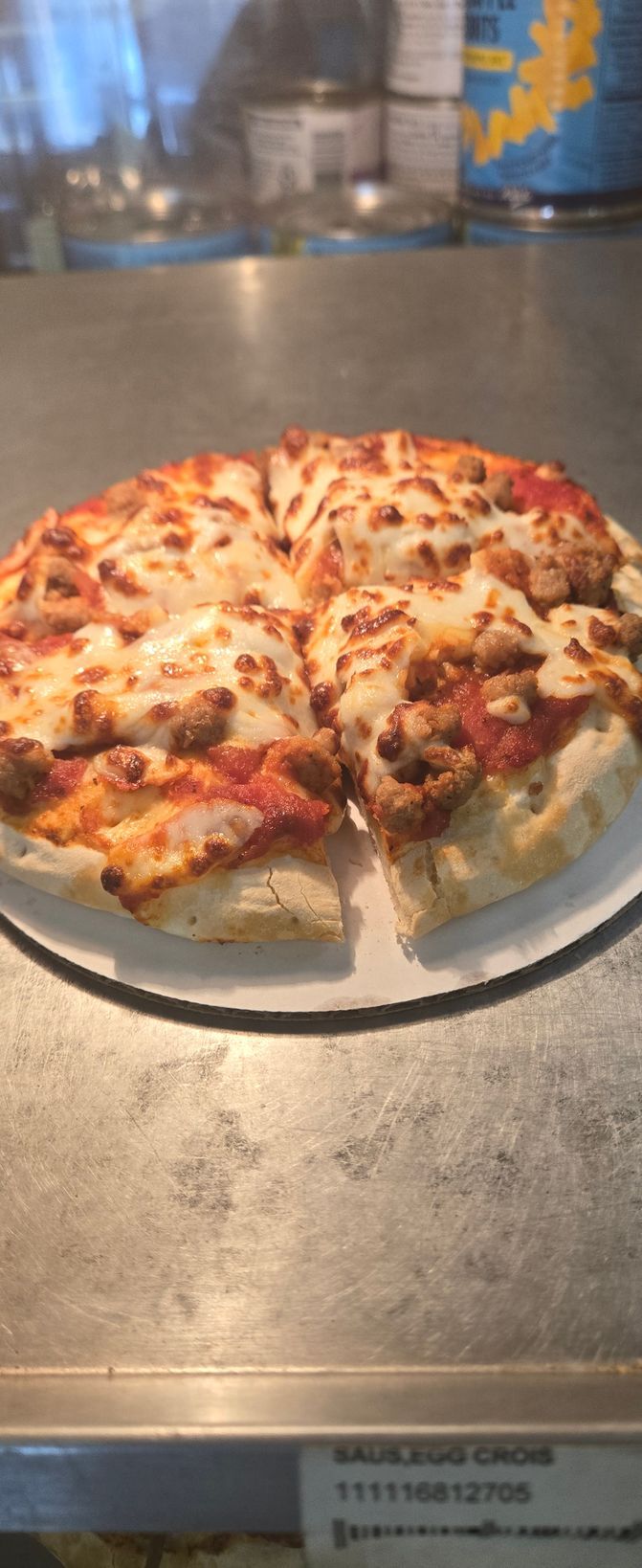 A pizza is sitting on a white plate on a counter.