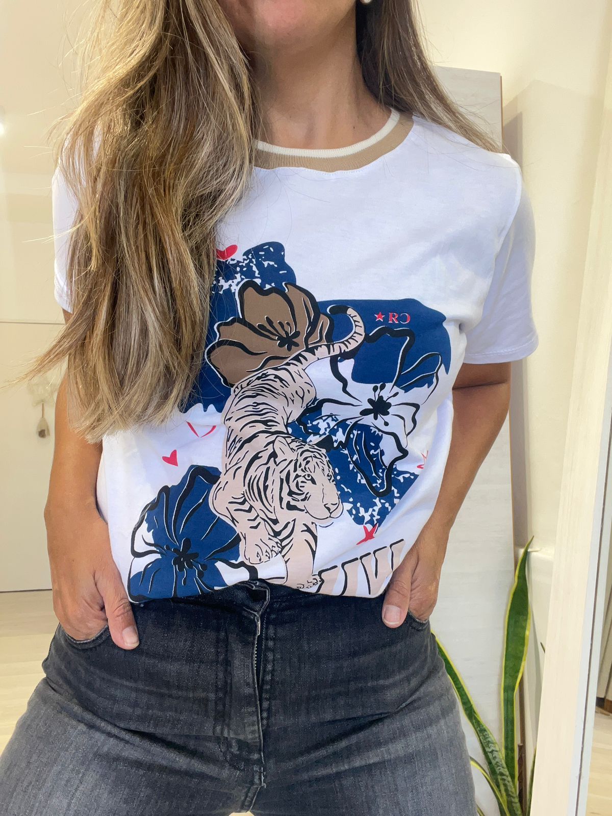 Una mujer lleva una camiseta blanca con un dibujo de flores.