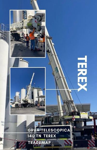 Una grúa telescópica Terex de 140 toneladas en una obra, con grandes silos industriales blancos al fondo.