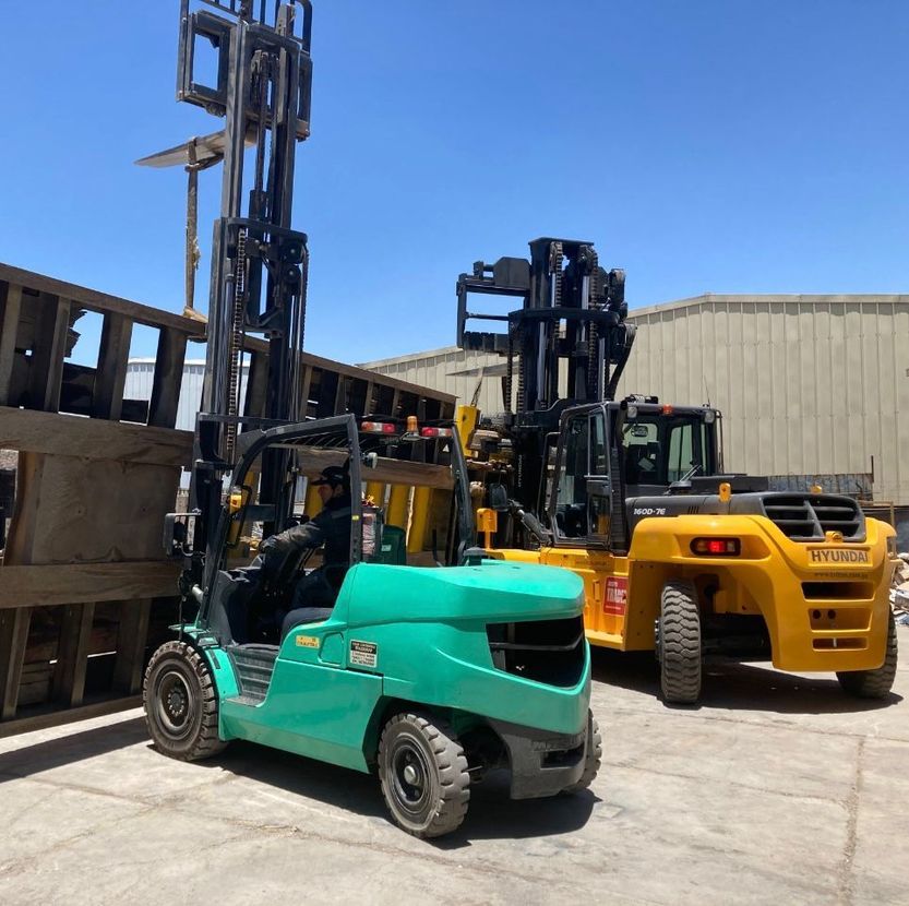 Un trabajador con un chaleco reflectante observa cómo una excavadora amarilla
