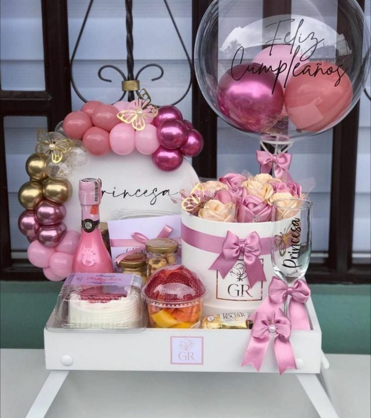 Canasta de regalo de cumpleaños con globos, flores y dulces. Tema rosa y dorado. Globo de