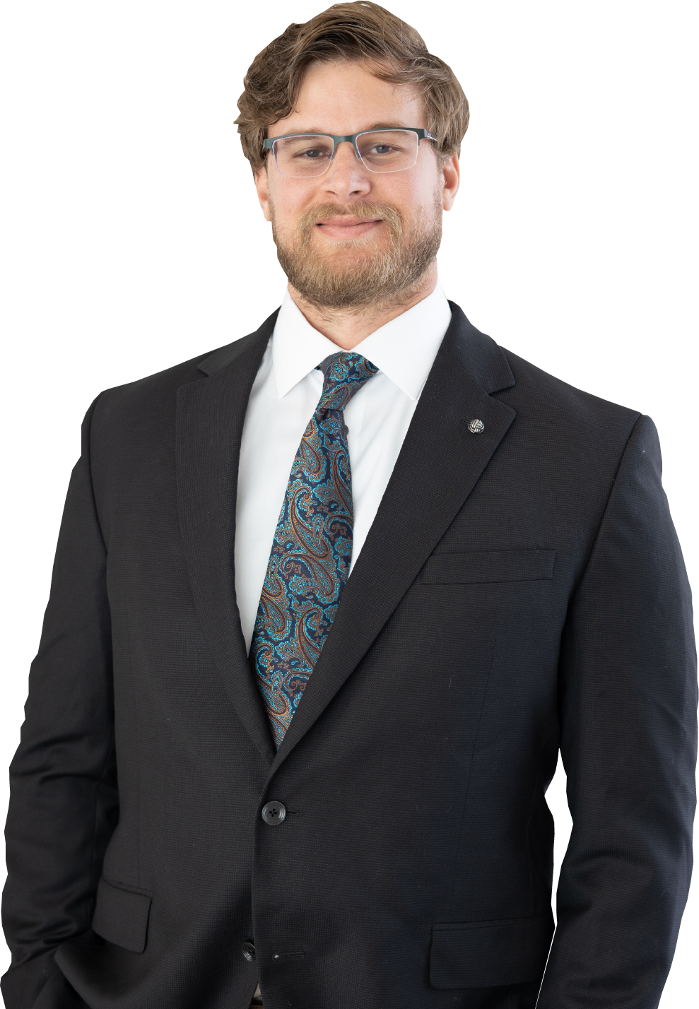 A person wearing a suit, white shirt, and patterned tie, posing against a white background.