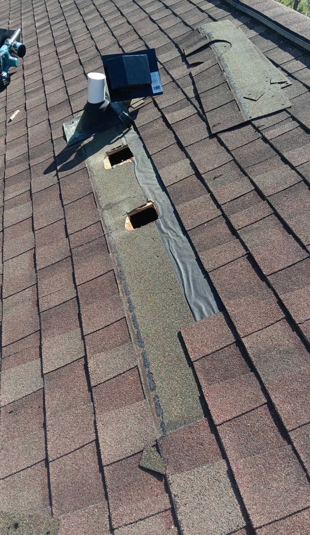 Roof with a vent pipe and flashing over brown shingles, viewed from above