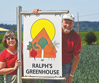 Two people smiling, holding a sign for 