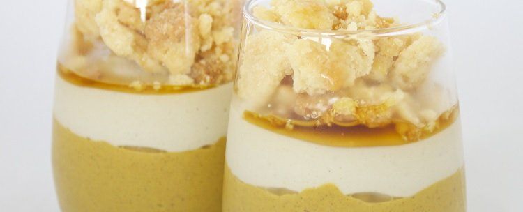 Two layered desserts in glasses, featuring a yellow base, white cream, caramel drizzle, and topped with a crispy crumble.