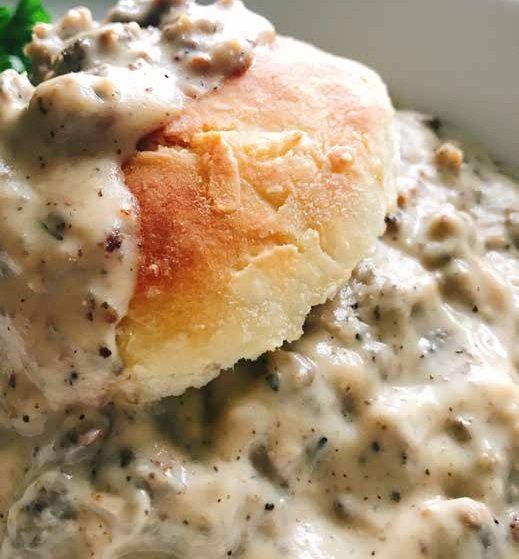 Biscuits and gravy: A fluffy biscuit sits atop a creamy, sausage-filled gravy, a classic breakfast.