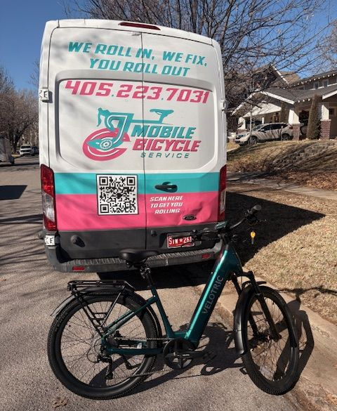 Cyclist with helmet repairing a green road bike on a road, outdoors.