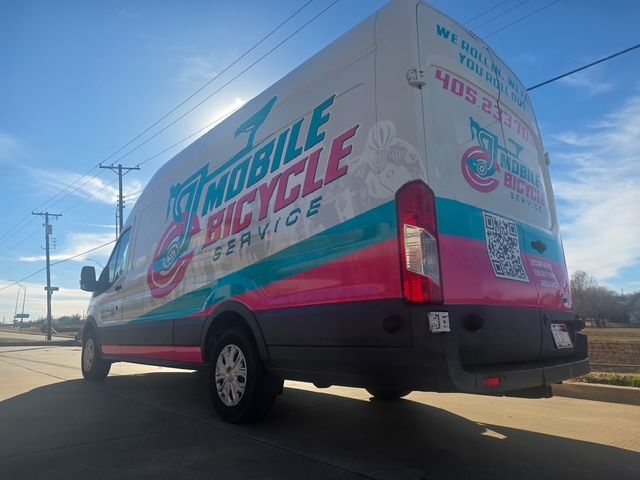 Close-up of a bicycle's chain and gears; the frame is red and white.