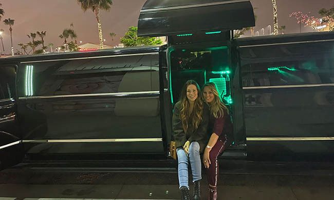 Two Women Sitting at the Door of Limo — Los Angeles County, CA — AA Limo Services