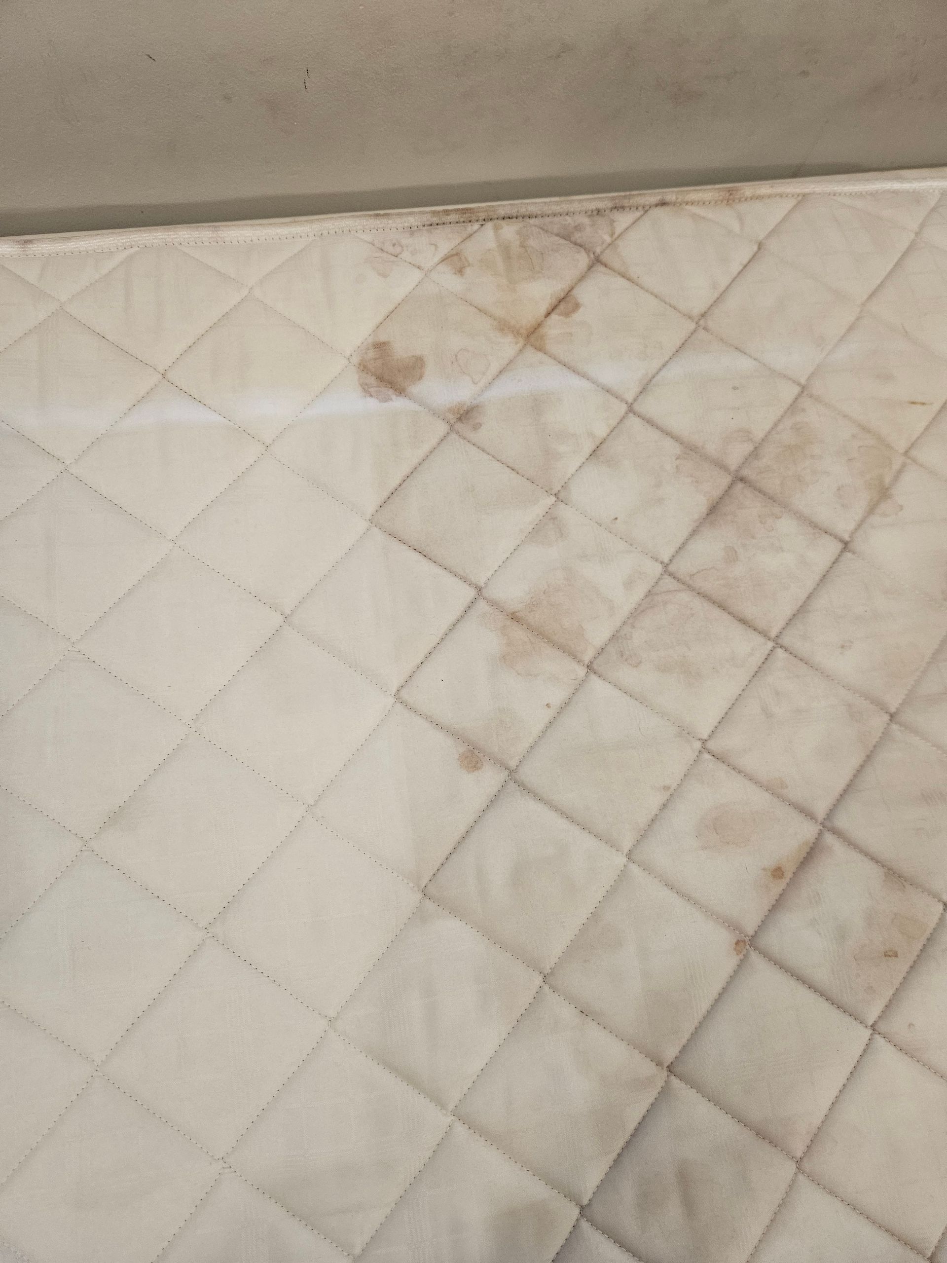 Top down view of a mattress being cleaned, one side is clean and the other is dirty — Pinnacle Carpet & Upholstery Cleaning In Wyong, NSW