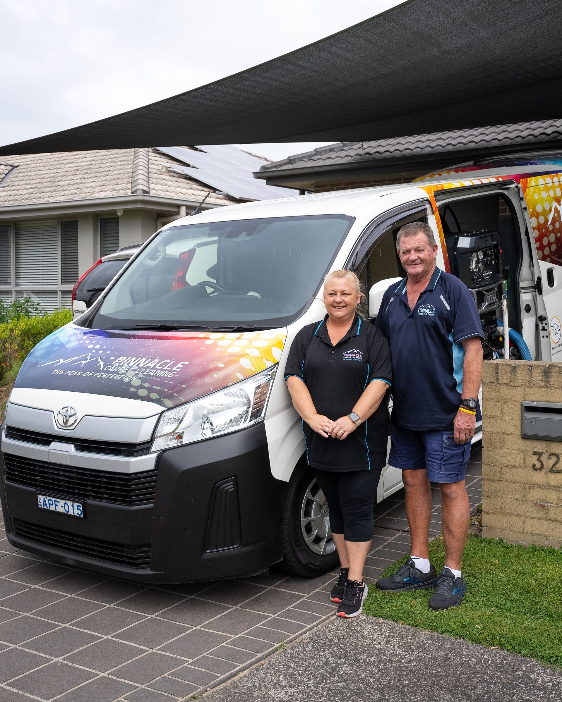 A man and a woman are standing in front of a van. — Pinnacle Carpet & Upholstery Cleaning In Wyong, NSW